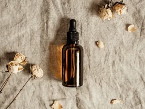 A small glass bottle of CBD oil next to dried flowers on a linen cloth. Read the blog 'CBD Oil Strength Explained - Which One Is Best For You?'.